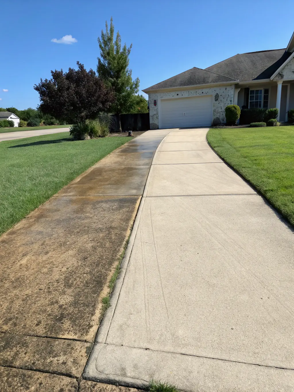 A before-and-after photo of a driveway in Inverness, FL, showcasing the dramatic results of Grime Off's driveway cleaning service.